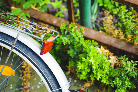 Detail of bicycle fender and wheel. Close up of back side view on decorative bicycle wheel in garden outside with copy space for textの写真素材