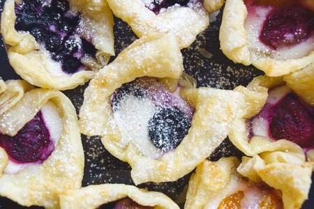 Delicious cakes with powder and various berries. Currant and strawberry. Flat lay close up