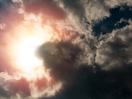 Storm clouds and sun behind. The sky a background with copy space for textの写真素材