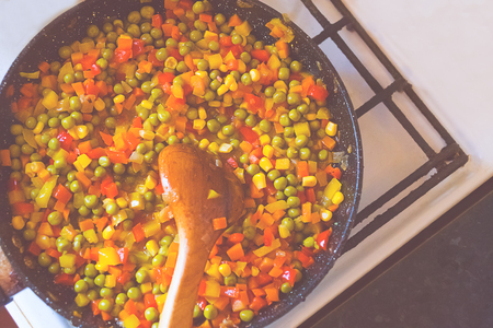 Fried carrots with peppers and peas on the old pan. Close-up.の写真素材