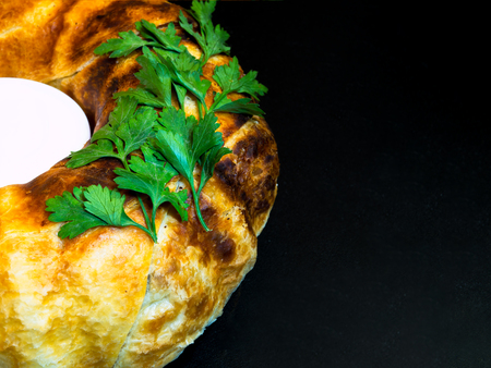 Layer-cake with chicken, mushrooms, parsley, cheese and sour cream in the middle on the black tableの写真素材