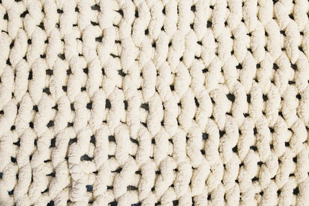 Beige yarn blanket on the bed. Texture background.の写真素材