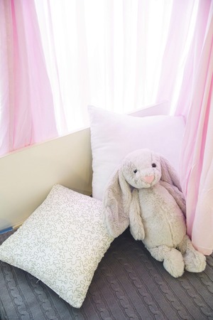 Cute bunny toy on bed in baby roomの写真素材