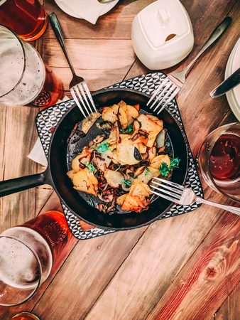 A lot of beer. Fried potatoes in a frying pan in the middle of the table. Flatlayの写真素材