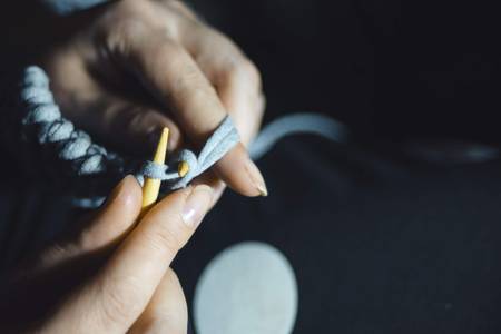 Close-up portrait of a beautiful female hands with needles and threads for knittingの写真素材
