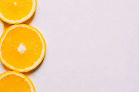 Juicy slices of an orange on a white, fruity background, top view. Copy space for textの写真素材