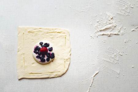 Cooking delicious sweets with jam and powder to tea.Top view .Not cooked cake with I years of strawberries in the middle lies on a white table. Summer day. Flat lay with copy space for text.の写真素材