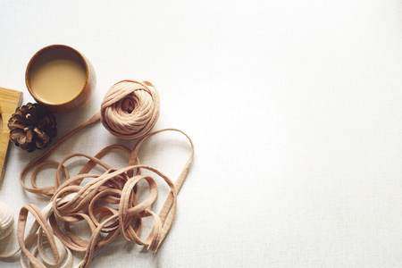 Top view of a cookie with coffee and spruce cone and a tangle on the tableの写真素材