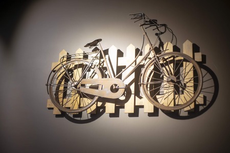 A historic vintage bicycle hanging on wooden boards on the wall, a concept decoration and art.