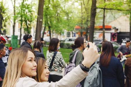 BISHKEK, KYRGYZ REPUBLIC - APRIL 14, 2018: Selfie time. Handsome friends making selfie and smiling while resting at festival.のeditorial素材