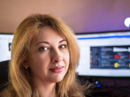Portrait of woman with computer on background and purple light. Summer day. Copy space for text.の写真素材