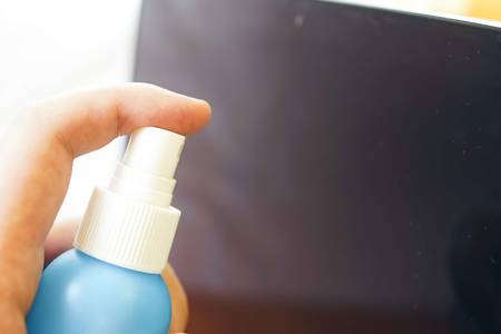 Close up of hands cleaning the screen with rag spray bottle detergent. Horizontal photo banner for...