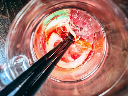 Grapefruit juice in a glass with three black tubes. Sunny day. Hot Summer.の写真素材