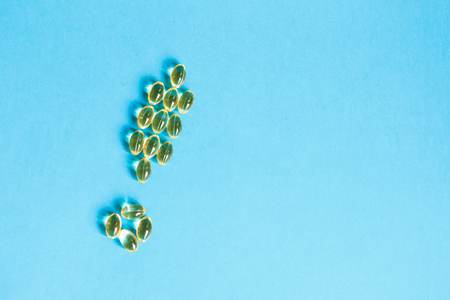 Yellow pills laid out in the form of an exclamation mark on a blue backgroundの写真素材