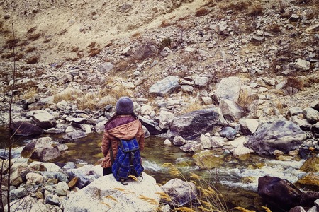 Hiker woman with backpack. The female sitting on the rock mountain , relaxing on the mountain.