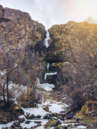 Ice waterfall in the peak slope. Frozen snow at mountain cliff at waterfall in winter season.の写真素材