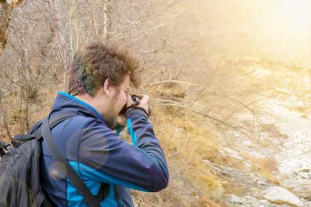 Photographer taking a picture in mountains. Nature Photography Concept. Professional Nature Photographer and the Mountainの写真素材