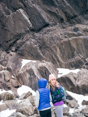 Hikers in the mountains. Two women in the mountains against the background of stone rocksの写真素材