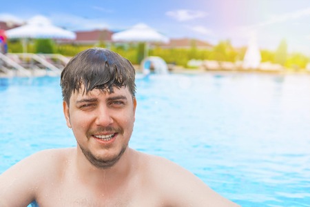 Man swimming in the pool. Young guy looks forward. He is swimming in pool during vacation.の写真素材