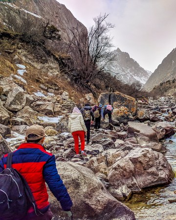 Hikers in the mountains. Group of tourists with backpacks descends down mountain trail. Beautiful inspirational landscape, trekking and activity.の写真素材