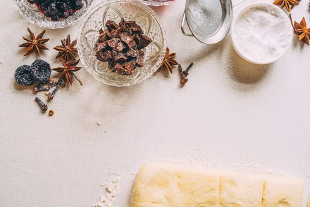 Vase with chocolate in powdered powder and a plate of powder and dried plum and licorice along with the pastry and flour lie on a white desk. Sunny day. Top view with Copy space for text.の写真素材