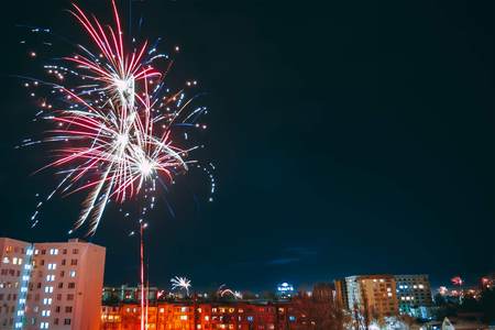 Whole city celebrating the New Year or any national event with fantastic multi-colored fireworks, copyspace on the night sky.の写真素材