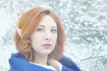 Elf Fairy woman. A girl is an elf, stands in the middle of the winter snow forest.の写真素材