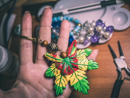 Spring necklace. Background of polymer clay. Colorful bright green, red and yellow accessory in the foria leaflet.の写真素材