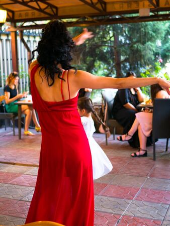 Bishkek, Kyrgyzstan - June 30, 2017: Girl in red dress dancing. Elegance Latino dancer girl in action.のeditorial素材