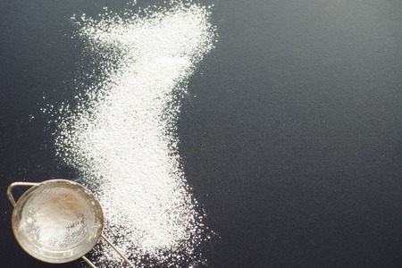 Powder scattered on a black table. The process of cooking deliciousness for tea drinking. A clunky cook. top viewの写真素材