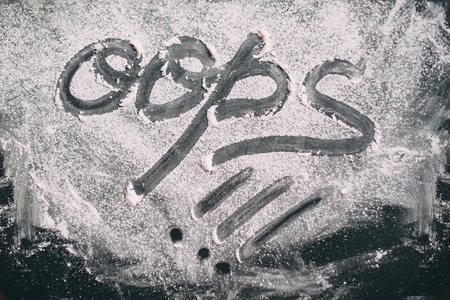 Ripped powder in the form of the word "oops" on a black table top viewの写真素材