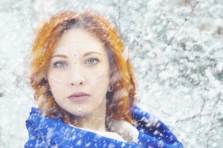 Elf Fairy woman. A fairy elf princess with snow ice on winter with blue hoodie.の写真素材