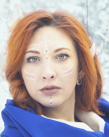 Elf Fairy woman. Fairy elf in a cold winter. Lost red-haired girl in the forest.の写真素材