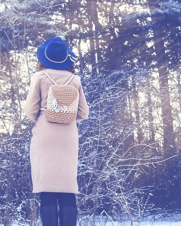 Portrait of young redhead woman in winter forest.