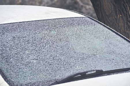 Frozen car window. Rear window of the car with a janitor covered with snow. In the winter, the car...