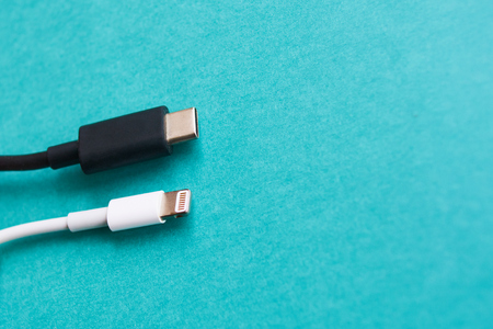 Closeup of USB type c and lightning cable on blue background with copyspace. Top viewの写真素材
