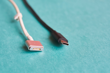 Black Usb type c and white magsafe cable on blue background. Macroの写真素材