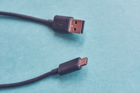 Closeup of USB type a and usb type c cables on blue background.の写真素材