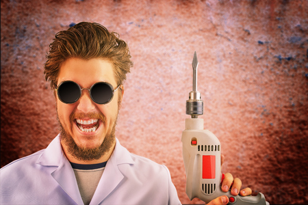 Freaky mad doctor in white coat and dark sunglasses with drill in hand on creepy red background. Halloween conceptの写真素材