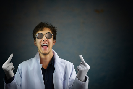 Laughing man scientist  in white robe and sunglasses giving you the fingers. Flipping off the middle finger bird gesture isolated on white background. The hands is selectively in focus.の写真素材