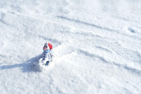 Beautiful snowman on natural snowdrift. Little funny white snowman in the snowbank.の写真素材