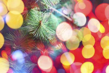 Christmas or New Year fir tree with decorative lights. Branch of a Christmas tree adorned with a bright multicolored garland. Close upの写真素材