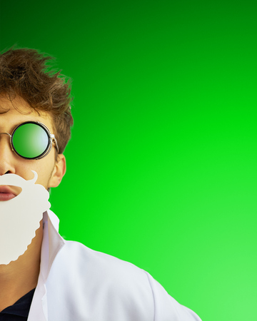 Crazy doctor with beard in glasses on green background. Copy space for text. Merry Christmas Doctor Santa Clausの写真素材