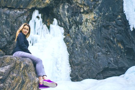 The woman sitting on the rock mountain. The female sitting on the rock mountain , relaxing on the top of the mountain, silhouette.の写真素材