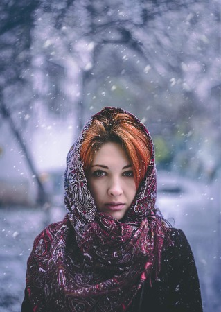 Portrait of a woman in a cold winter. Young odd beautiful adorable lovely girl in knitted sweater portrait outdoor in cold winter forest. Fashionable model with snow covered hair bang freezing.の写真素材