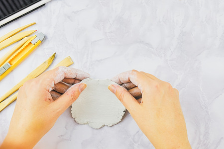 Clay bowl author decorating, pottery making. Carving of handmade crockery with special tools