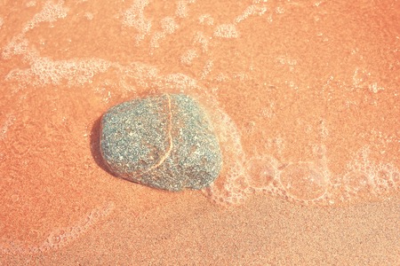 Rocks on the sand. Beautiful beach sand background with pebbles. Brown sandy texture with stones. Summer concept. Top view.の写真素材