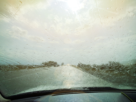 Travel in car. Element of design. View from car window on road. Rainy weatherの写真素材