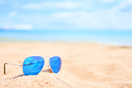 Blue sunglasses on sand beach. Vacation conceptの写真素材