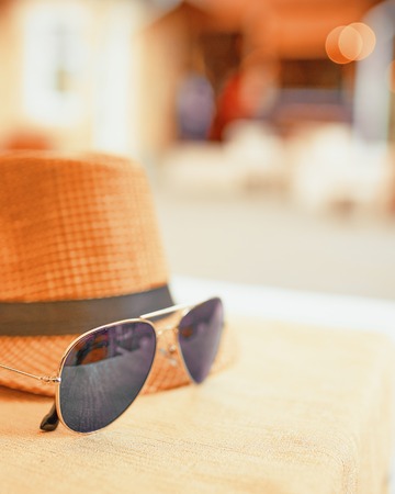 Hat and dark sunglasses on a hot day off on the table. Resort conceptの写真素材